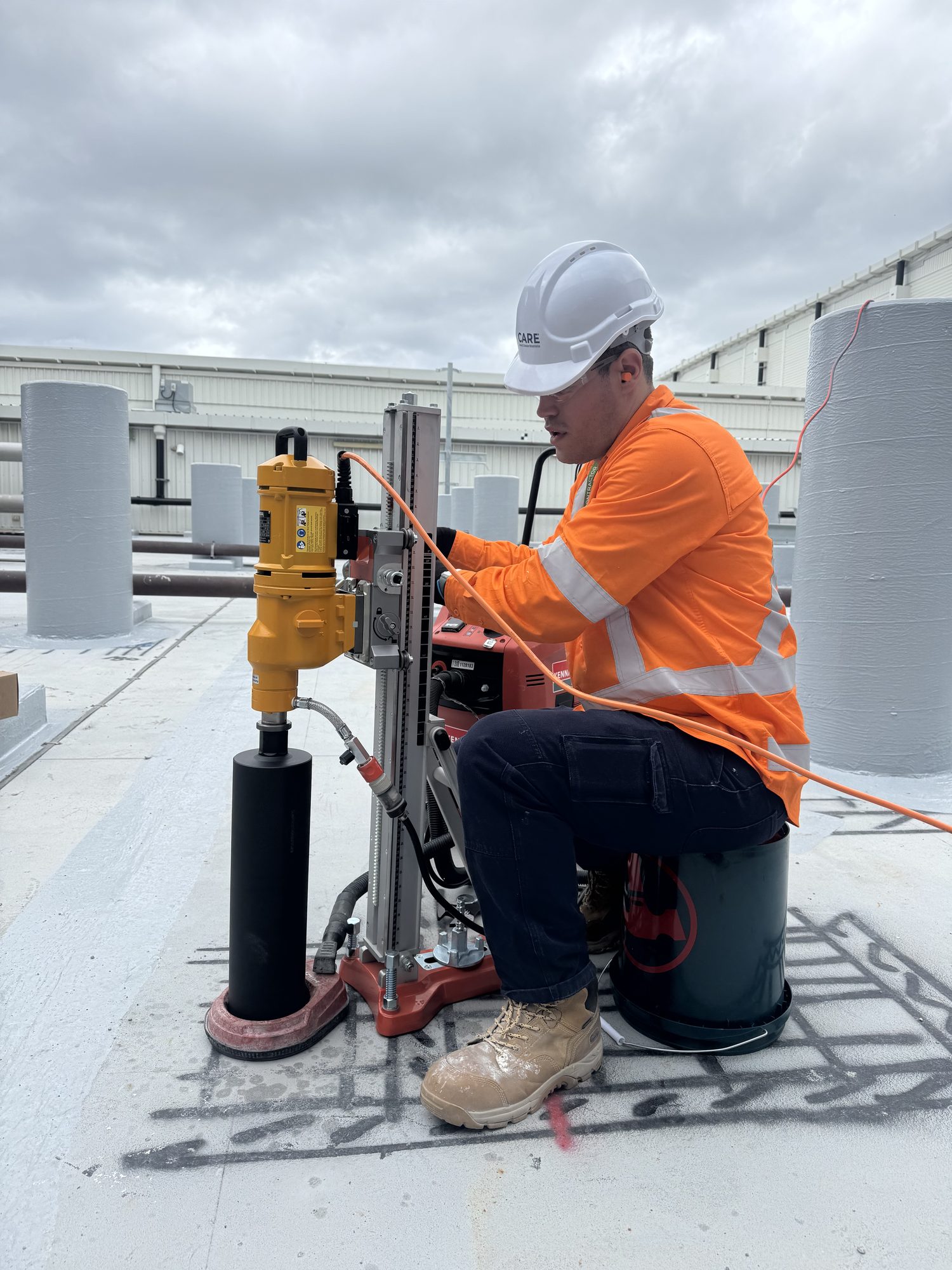 CARE operator diamond core drilling a concrete slab