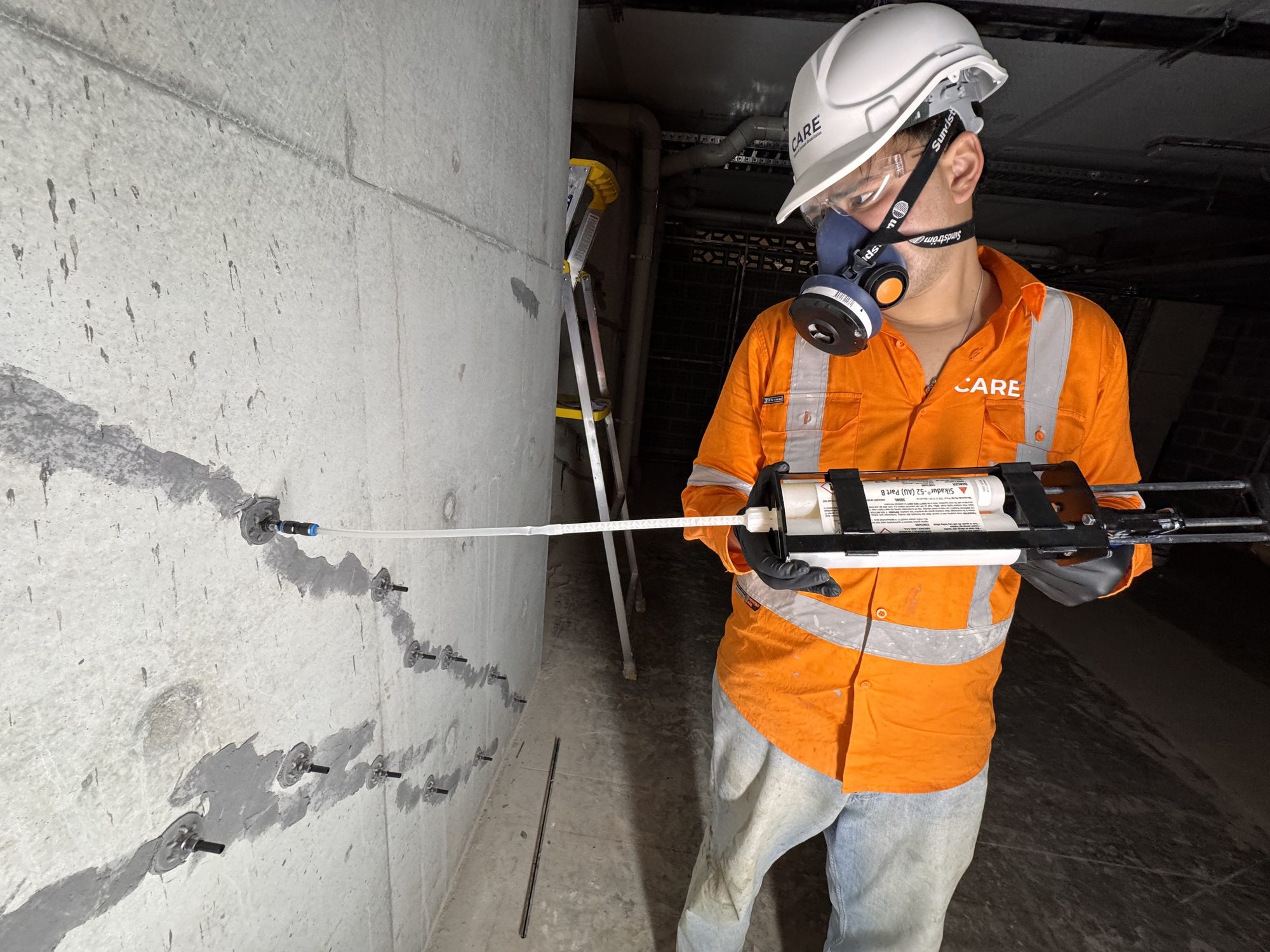CARE operator injecting epoxy resin into a concrete crack